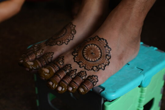 Bangalore, India 9th April 2024: Indian Groom wedding henna mehendi mehndi feet close up. Henna pattern. Traditional Rasam or rivaz of done with henna mehandi. Practiced in India and Pakistan.