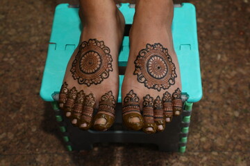Bangalore, India 9th April 2024: Indian bride's wedding henna mehendi mehndi feet close up. Henna...
