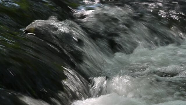 Streams of water splashing on a waterfall on a river