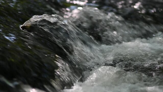 Streams of water splashing on a waterfall on a river
