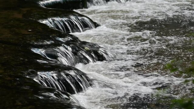 Fast flowing water through a waterfall with rock rapids on the Tanew River