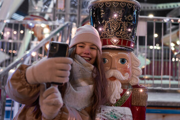 Young woman taking selfie with a nutcracker on Christmas Market