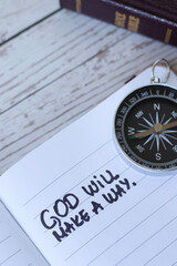 God will make a way, handwritten quote in notebook with compass and holy bible book. Christian...
