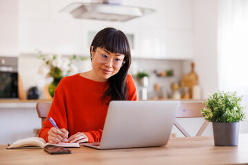 Mature woman taking online course at home using laptop computer