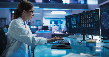 Hospital Research Laboratory: Female Medical Scientist Using Computer with Brain Scan MRI Images....