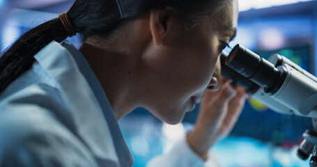Medical Development Laboratory: Close Up Portrait of Asian Female Scientist Using Microscope,...