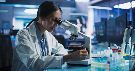 Medical Research And Development Center: Female Asian Scientist Using Microscope To Analyze Petri Dish Sample. Specialist Developing Innovative Medicine For Treating Mental Disorders Or Pain Relief.