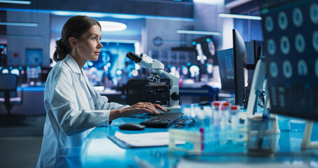 Medicine Development Laboratory: Caucasian Female Scientist Using Microscope, Analyzes Petri Dish...
