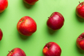 Many red apples on colored background, top view. Autumn pattern with fresh apple above view