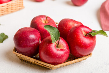 Ripe garden apple fruits with leaves in basket on wooden table. Top view flat lay with copy space