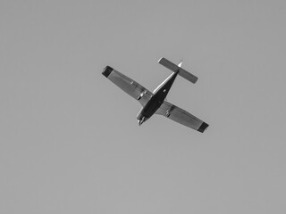 Single-engine plane flying in gray sky