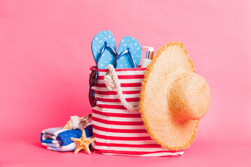 Stylish bag with beach accessories . Summer holiday concept. beach bag with straw hat with space...