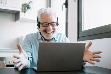 Video call concept.  Smiling senior caucasian businessman working online watching computer webcam...