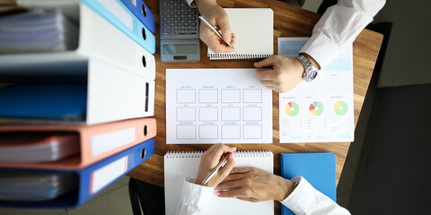 Businessman and businesswoman make work plan on office table with folder paper background. Business...