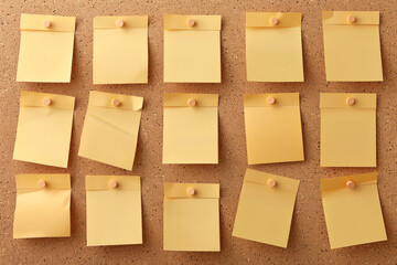 Multiple yellow sticky notes pinned on a corkboard arranged in a grid pattern