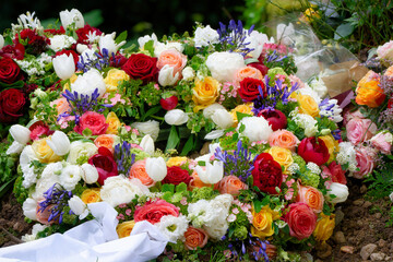 a funeral wreath with a white ribbon and many colourful flowers on a grave after a funeral