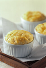 Baked souffle in three white containers on wooden tray