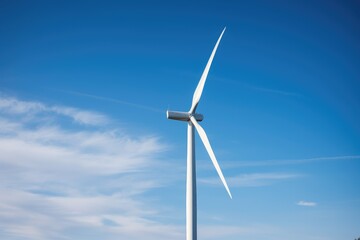 Fototapeta premium A tall wind turbine stands in the middle of a vast field, generating renewable energy through its spinning blades. Generative AI