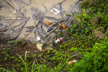 Pollution of river. Polluted lake with plastic waste and garbage. Ecological catastrophe on river. Plastic bottles, bags, cups, different kinds of debris.