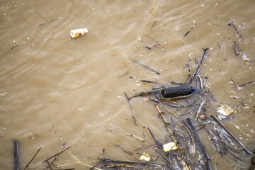 Pollution of river. Polluted lake with plastic waste and garbage. Ecological catastrophe on river. Plastic bottles, bags, cups, different kinds of debris.