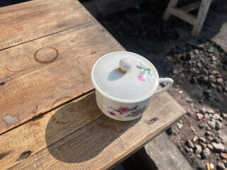 a cup with a coffee lid at the end of the wooden table