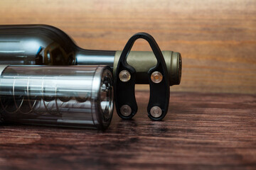 electric corkscrew, a bottle of wine and a bottle opener lie on a dark wood background.