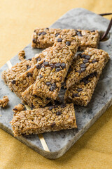 Various granola bars on table background. Cereal granola bars. Superfood breakfast bars with oats, nuts and berries, close up.