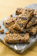 Various granola bars on table background. Cereal granola bars. Superfood breakfast bars with oats, nuts and berries, close up.