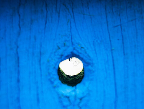 A close-up shot capturing the wood texture of blue-colored wooden gates, peephole. 