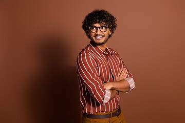 Photo of nice young man look empty space wear striped shirt isolated on brown color background