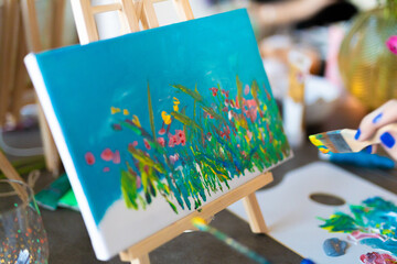 easel with paints and brushes