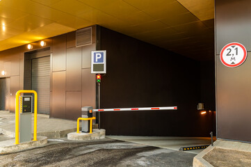 A parking garage with a red and white barrier