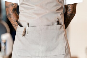 Cool barber in beige denim apron