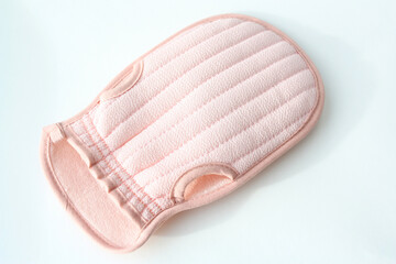 A washcloth is a mitten for washing the body. A pink washcloth white background with copy space.