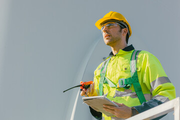 professional engineer male working outdoor with safety at wind turbines clean energy power station background, worker people with renewable energy technology for future concept. - 801166290
