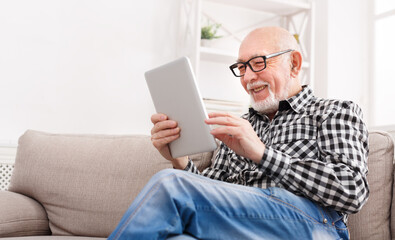 Fototapeta premium Senior man reading news on digital tablet