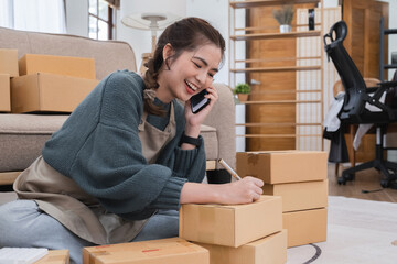 SME business entrepreneurs small in Asia Write shipping information on a cardboard box in home...