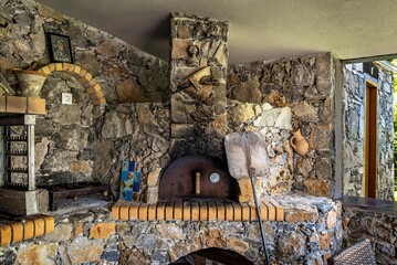 Stone oven and BBQ set in a charming summer kitchen. The rustic stone construction adds to the...