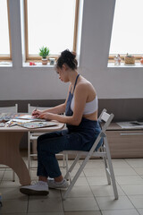 Young female artist paints a picture with oil on canvas in art studio