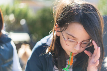 Portrait of a young beautiful asian girl drinking fresh juice outdoors.