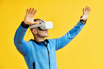 Man wearing virtual reality goggles over yellow background