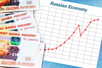 Banknotes of Russian ruble and rising chart of Russian economy.