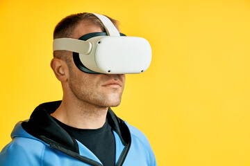 Man wearing virtual reality goggles over yellow background