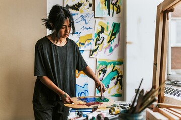 Woman artist mixing paint on a color palette