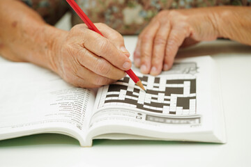 elderly woman playing sudoku puzzle game for treatment dementia prevention and Alzheimer disease.