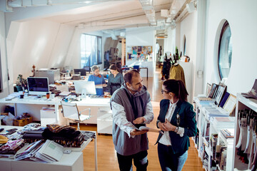 Colleagues discussing over a booklet in a creative office space