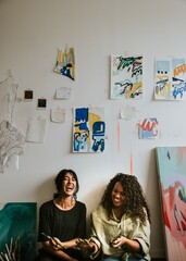 Woman artist friends exchanging ideas in their studio