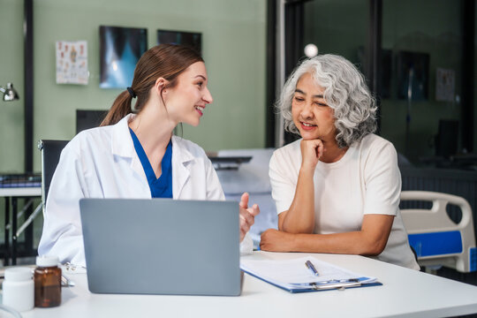 Monthly health check-ups and counseling sessions are provided to an elderly Asian woman by a Caucasian female caregiver, offering support, advice, and motivation.