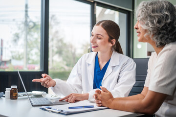 Obraz premium Monthly health check-ups and counseling sessions are provided to an elderly Asian woman by a Caucasian female caregiver, offering support, advice, and motivation.