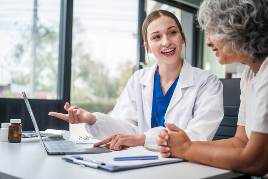 Monthly health check-ups and counseling sessions are provided to an elderly Asian woman by a Caucasian female caregiver, offering support, advice, and motivation.